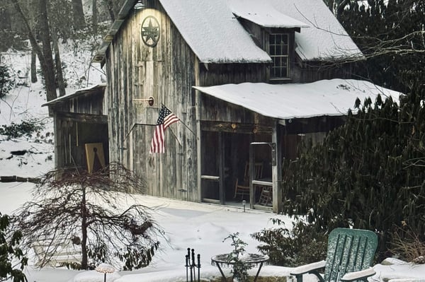 Nestled in a snowy landscape, this rustic cabin features a unique exterior and inviting outdoor space.
