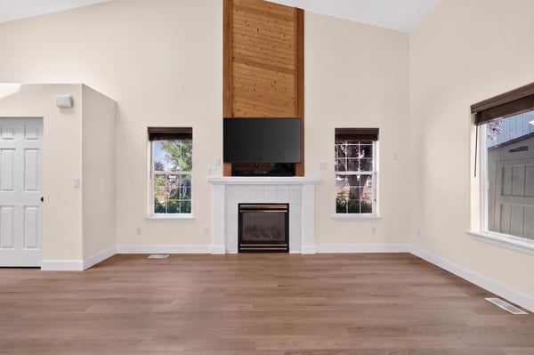 Spacious living area with large windows, inviting natural light, and a cozy fireplace for gatherings.