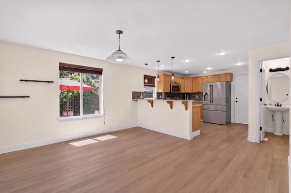 Bright, open living space featuring a modern kitchen and ample natural light with patio access.