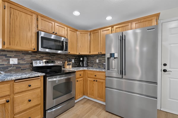Modern kitchen featuring stainless steel appliances, ample cabinet space, and a sleek backsplash for a functional touch.