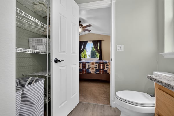 Cozy bathroom with convenient storage, leading to a bright bedroom with scenic views.