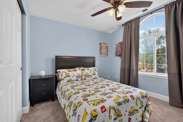 Cozy bedroom featuring playful decor, ample natural light, and a comfortable bed for restful nights.