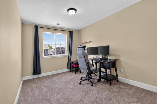 Bright and spacious office space featuring dual monitors and ample natural light, perfect for productivity.
