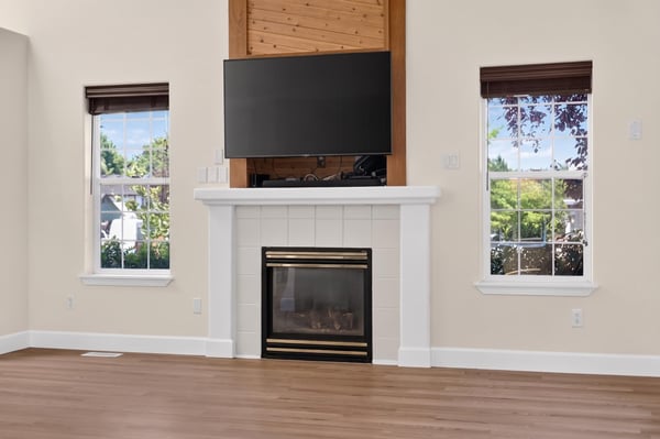 Bright living room featuring a modern fireplace, large windows, and a mounted TV for entertainment convenience.