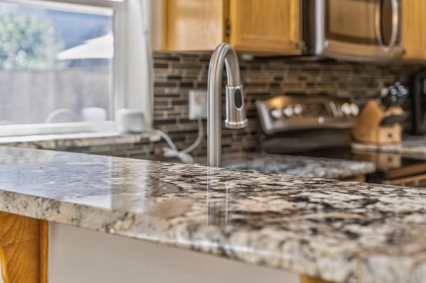 This modern kitchen features a spacious granite countertop, perfect for meal preparation and entertaining.