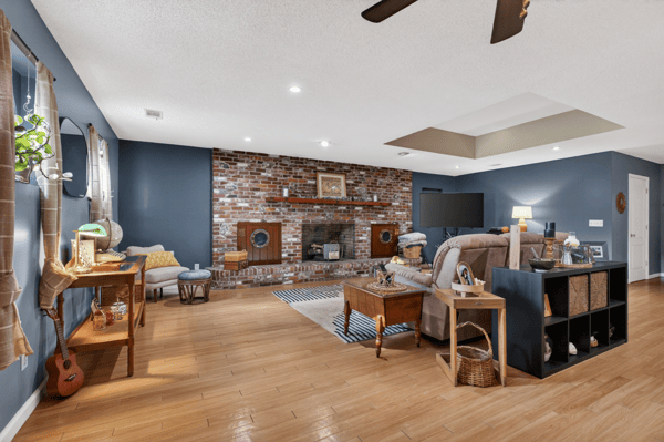 Spacious living area featuring a brick fireplace, modern amenities, and ample natural light for relaxation.