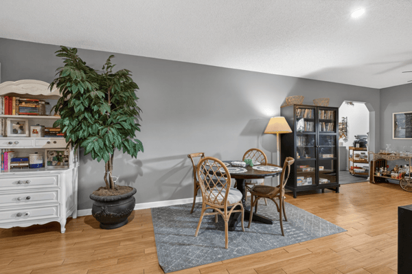 Bright and inviting living space featuring a cozy dining area and rich hardwood flooring throughout.