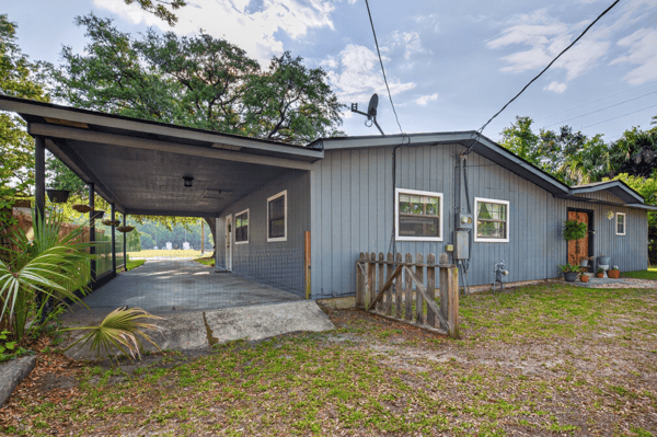 This versatile property features a spacious covered carport and a welcoming outdoor space for gatherings.