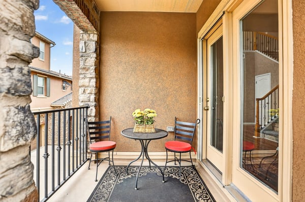 Enjoy morning coffee on this inviting balcony with a cozy table and scenic views.