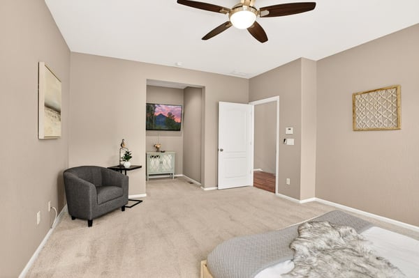 Spacious bedroom featuring neutral tones, a cozy seating area, and a welcoming ambiance perfect for relaxation.