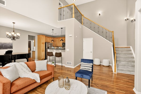 Spacious open living area features high ceilings, modern kitchen, and abundant natural light throughout.