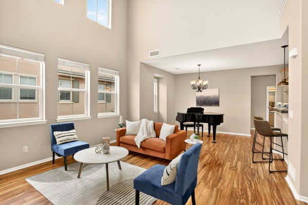 Light-filled living space featuring high ceilings and an inviting blend of modern and comfortable furnishings.