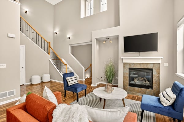 Spacious living area with high ceilings, modern finishes, and a cozy fireplace, perfect for entertaining.