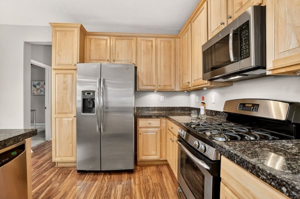 Modern kitchen featuring stainless steel appliances, ample cabinetry, and sleek granite countertops for a functional cooking space.