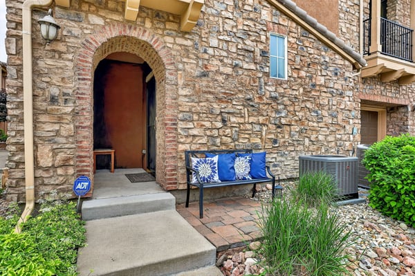 Discover a welcoming entrance with natural stone features and comfortable outdoor seating for relaxation.