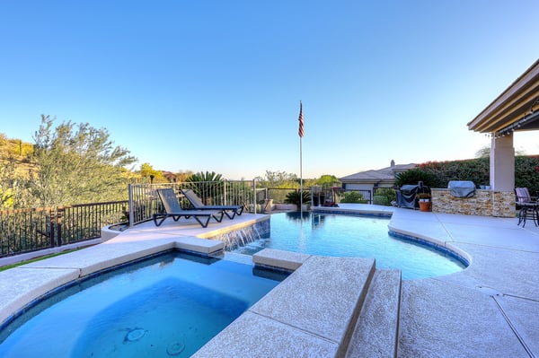Pool and spa with cascading waterfall feature enhance this Scottsdale backyard, offering a peaceful and luxurious retreat.