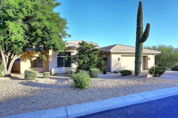 Front exterior showcases desert landscaping, natural textures, and Scottsdale design for timeless curb appeal.