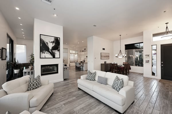 Open-concept living and dining space with fireplace, wood flooring, and modern finishes creates a versatile Scottsdale entertaining area.