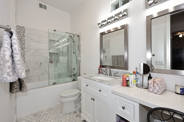 Updated bathroom with tiled shower, sleek vanity, and contemporary lighting enhances functionality and style in this Scottsdale home.