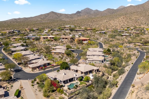 Aerial showcasing Scottsdale community with scenic mountain backdrop, quiet streets, and attractive desert-style homes.