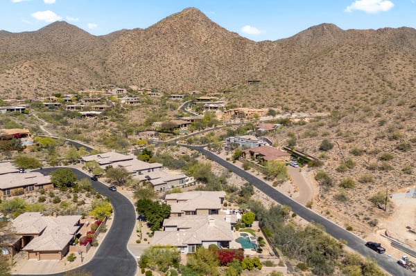 Wide aerial capturing Scottsdale desert terrain, surrounding homes, and natural mountain beauty in this desirable location.
