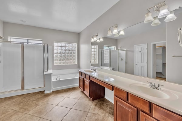 Well-appointed primary bathroom with dual vanities, soaking tub, and separate shower, offering comfort and convenience.