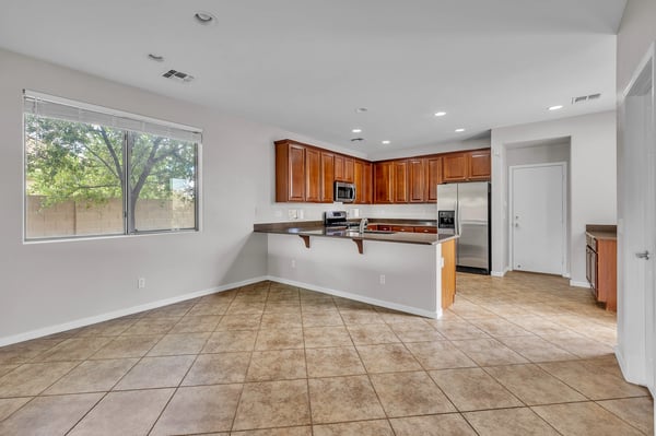 Efficient kitchen design with breakfast bar, stainless appliances, and ample storage ideal for daily living and entertaining.