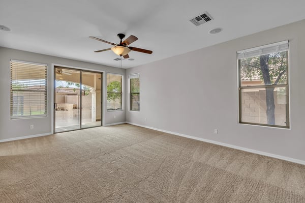 Comfortable living room with large windows and soft carpeting, creating a bright and airy space for relaxation.