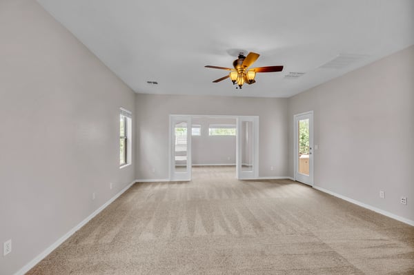 Spacious primary bedroom with ceiling fan and access to a private sitting area, offering added flexibility and comfort.