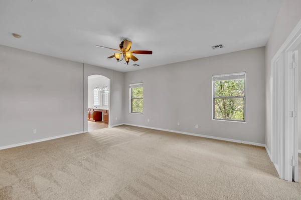 Cozy bedroom with neutral finishes and large windows, ideal for guests, family, or a home office.