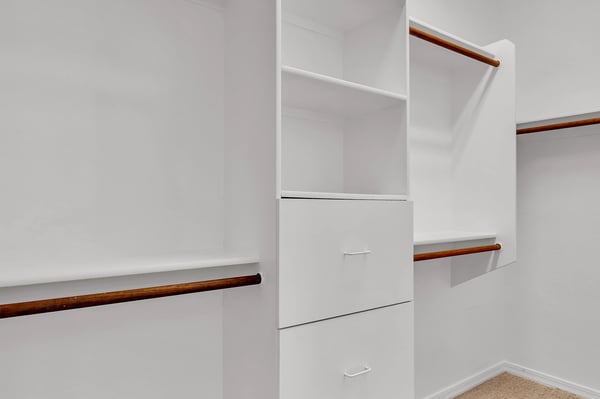 Well-designed walk-in closet with built-in shelving and hanging areas, providing organized storage within the primary suite.