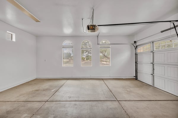 Clean and open two-car garage with high ceilings and extra storage potential, ideal for vehicles and equipment in Goodyear.