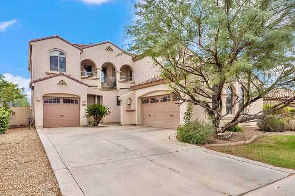Generous driveway with multiple garage spaces, ideal for extra parking and storage needs in this Goodyear home.