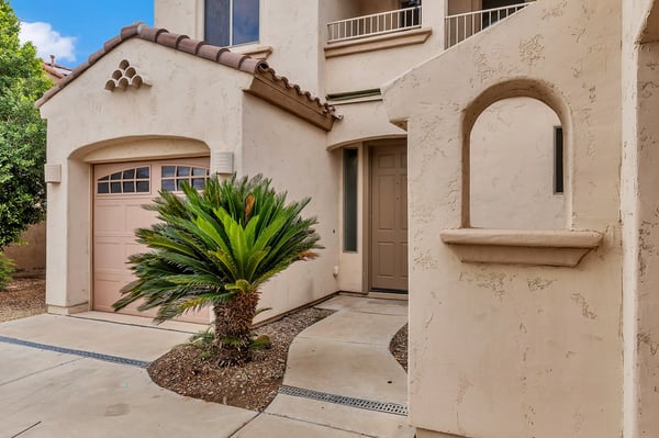 Front entry with classic arched details and landscaped surroundings, creating a welcoming first impression in this Goodyear home.