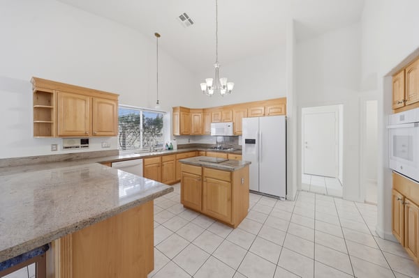 Large center island and granite surfaces create a functional and inviting kitchen workspace ideal for meal prep, hosting, and casual dining.