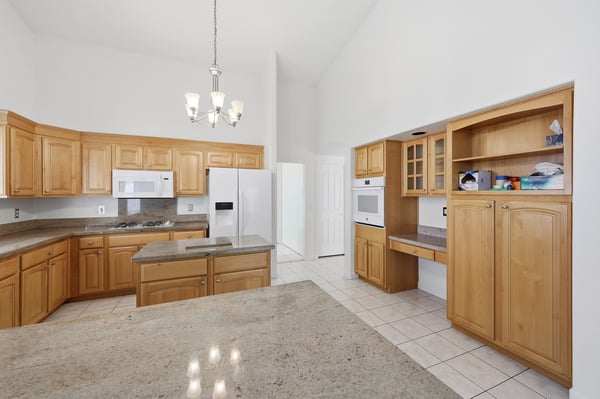 Spacious kitchen with built-in wall oven, custom cabinetry, and open design offers timeless style and practical functionality in this Peoria home.