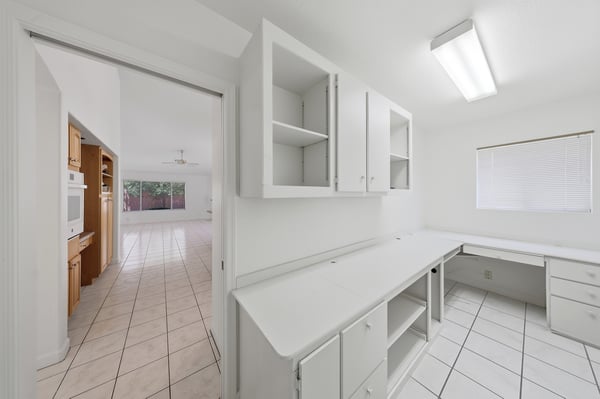 Versatile office space with built-in cabinetry and expansive work surfaces is perfect for remote work, hobbies, organization, or creative pursuits.