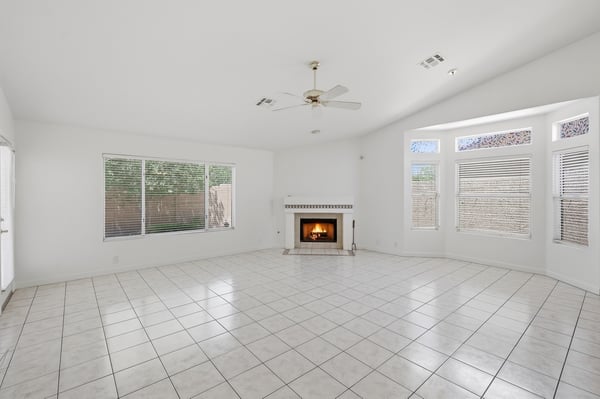 Spacious living area with oversized windows and fireplace offers bright interiors and a welcoming atmosphere in this beautifully maintained Peoria property.