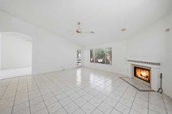 Fireplace-centered family room with open design and natural light provides a cozy yet spacious setting for entertaining and relaxing year-round.