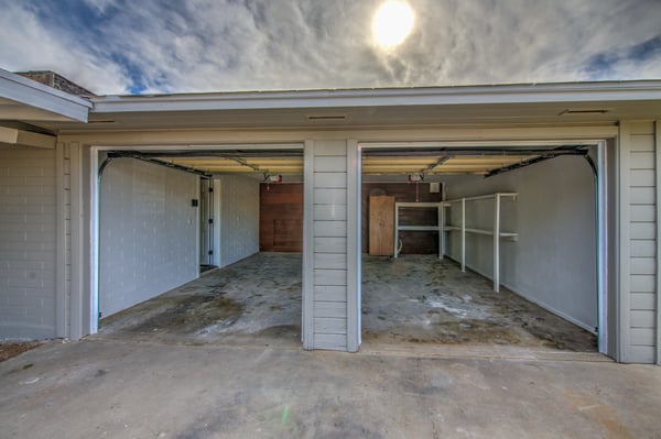 This roomy two-car garage features built-in shelving, ample storage, workspace potential, and convenient access, making it ideal for vehicles, projects, and organization.