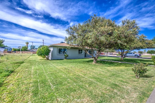 This generous front lawn offers beautiful green space, mature landscaping, and a welcoming approach that enhances the home's attractive exterior and neighborhood appeal.