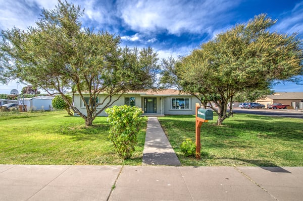 Attractive landscaping, fresh exterior paint, and a charming covered entrance combine to create a warm and inviting first impression for this Buckeye property.