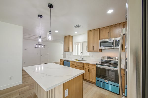 Featuring custom white oak cabinets, sleek quartz countertops, stainless steel appliances, and a generous island, this remodeled kitchen is designed for both style and convenience.