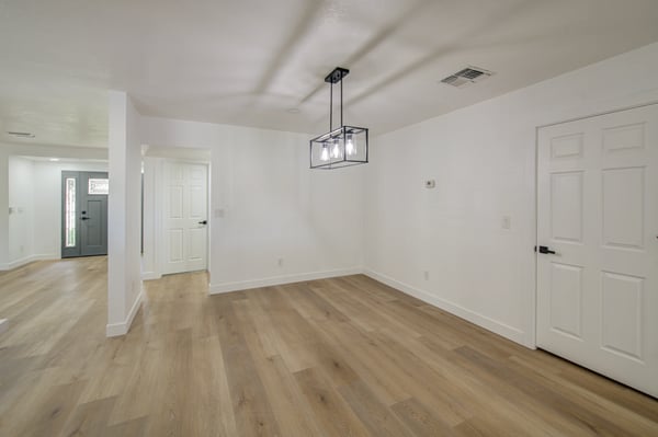 This open dining area offers flexible space, updated flooring, modern lighting, and seamless access to the remodeled kitchen for effortless entertaining.
