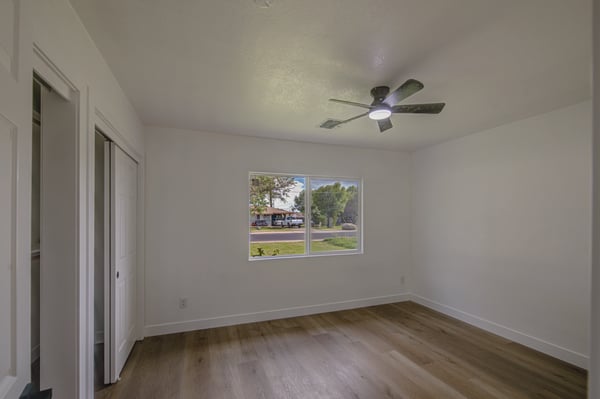 Freshly updated with modern flooring, neutral finishes, and a ceiling fan, this spacious bedroom easily adapts to guests, family, or a productive home office.