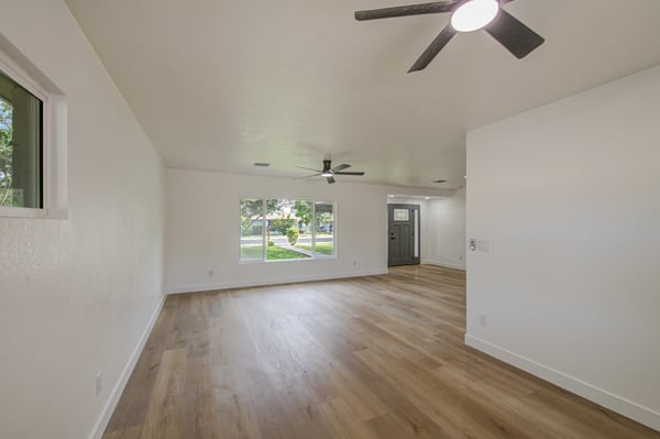 Large picture windows brighten this inviting living room, highlighting the home's modern flooring, fresh interior updates, and comfortable open-concept design.