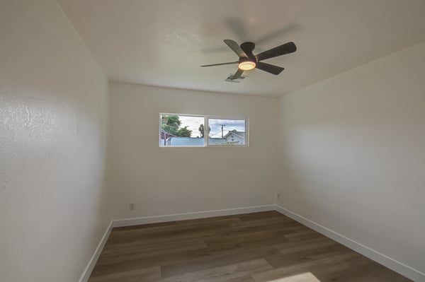 Offering updated flooring, neutral finishes, and a ceiling fan, this comfortable bedroom adapts easily for family, guests, or a productive home office.