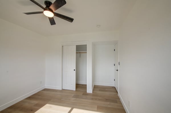 Updated flooring, fresh paint, ceiling fan, and a spacious closet make this bright bedroom an excellent option for family, guests, or flexible living space.