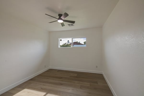 This welcoming bedroom features modern flooring, fresh interior finishes, ceiling fan, and versatile space suitable for guests, children, or a home office.