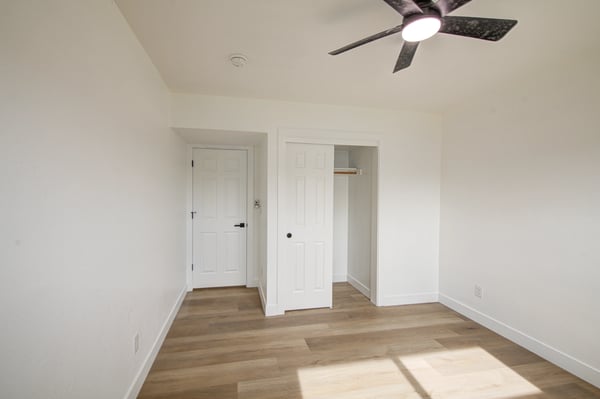 A bright window, updated flooring, modern ceiling fan, and neutral finishes create a comfortable bedroom ready for immediate enjoyment.